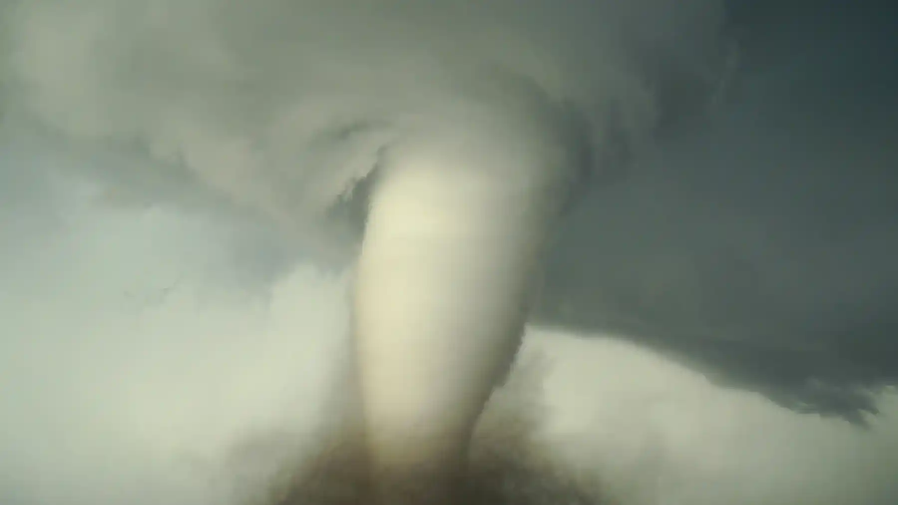 Une tornade en forme de vortex dans un paysage vert de gris tourmenté