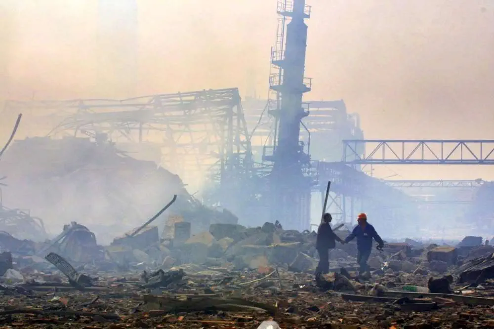 Vue de environs de l'usine après l'explosion survenue le 21 septembre 2001 dans l'usine chimique AZF de Toulouse, deux ouvriers se serrent la main.